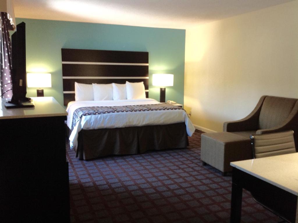 Habitación de hotel con cama y silla en Americas Best Value Inn New London Mystic, en New London