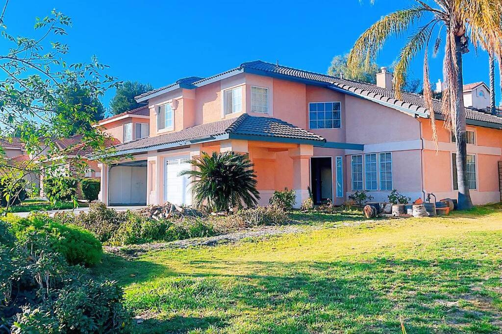 una gran casa de naranjos con palmeras en el patio en Quiet comfortable whole house en Riverside
