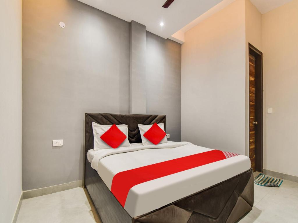 een slaapkamer met een bed met rode kussens bij Super OYO Flagship Hotel Iris Lite in New Delhi