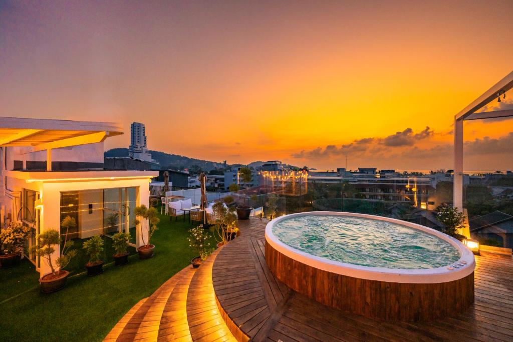 a hot tub on the roof of a building with a sunset at La Vista Patong Hotel in Patong Beach