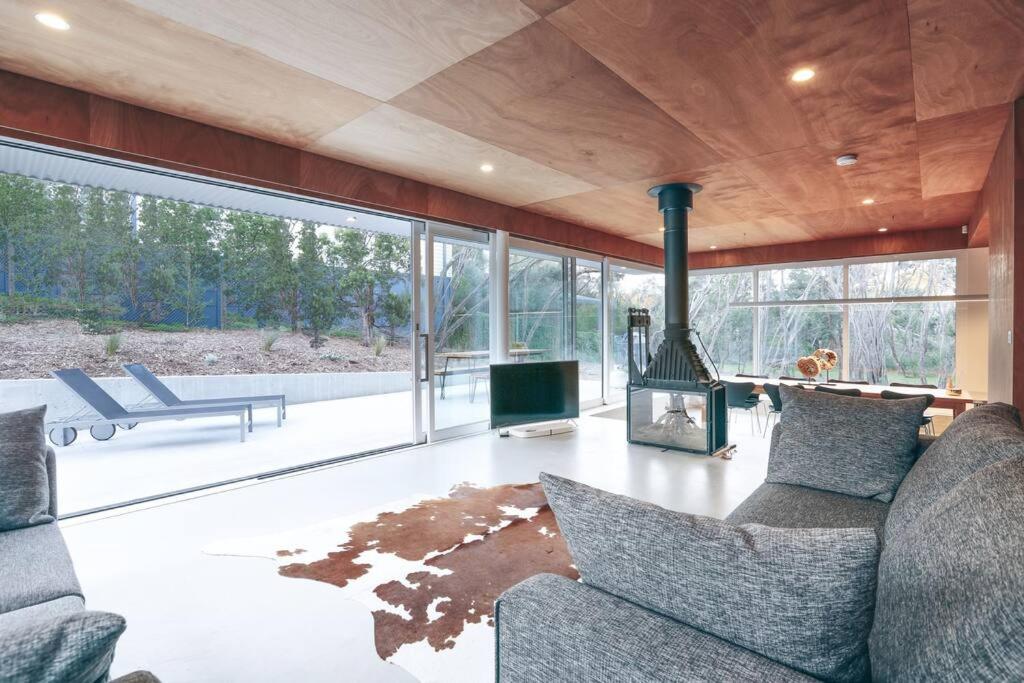 a living room with a fireplace and a couch at Rye Glass House - Architectural Escape in Rye