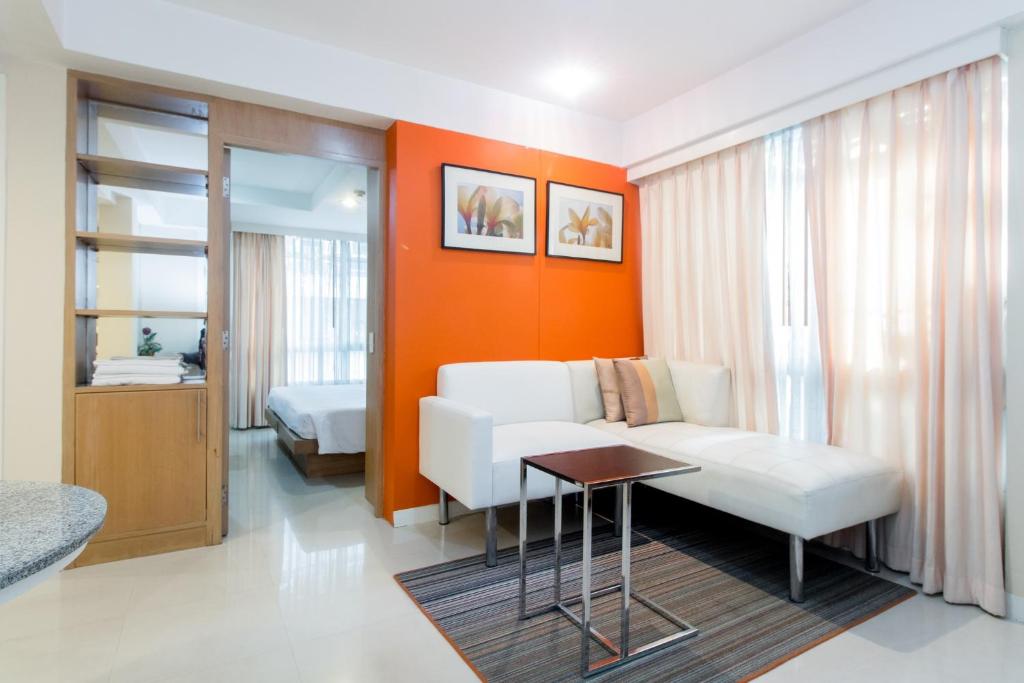 a living room with a white couch and an orange wall at Silom Convent Garden in Bangkok