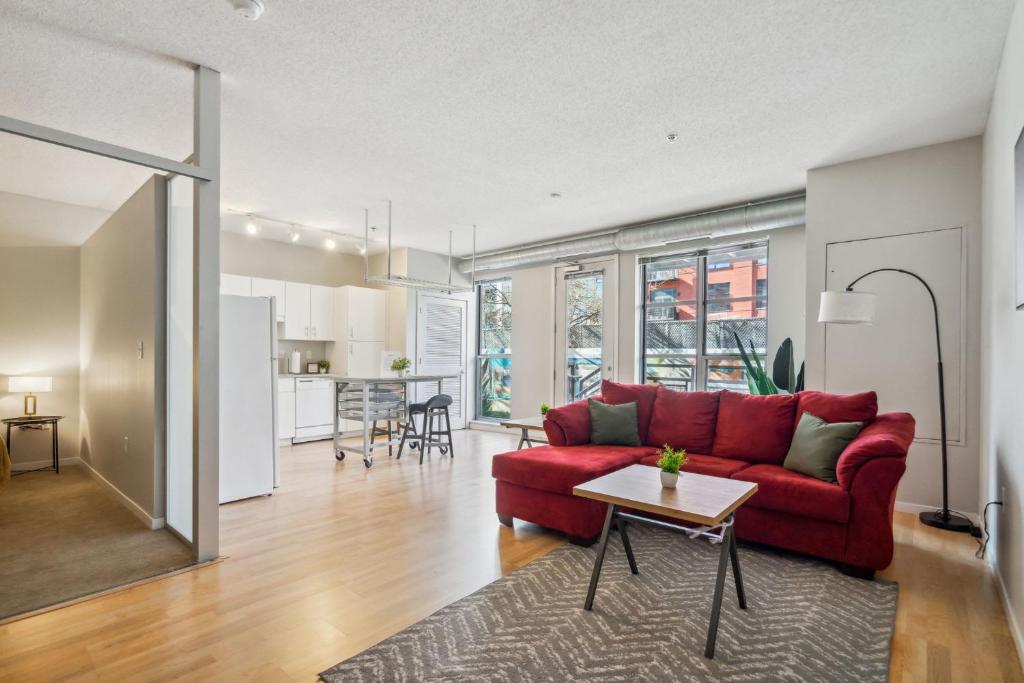 a living room with a red couch and a table at CozySuites Mill District pool gym # 07 in Minneapolis