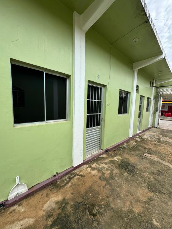ein leeres Gebäude mit grünen Wänden und Fenstern in der Unterkunft Kitnet mobiliada em Parauapebas in Parauapebas