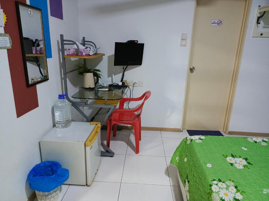 Habitación con mesa, silla y TV. en Homestay z, en Shah Alam