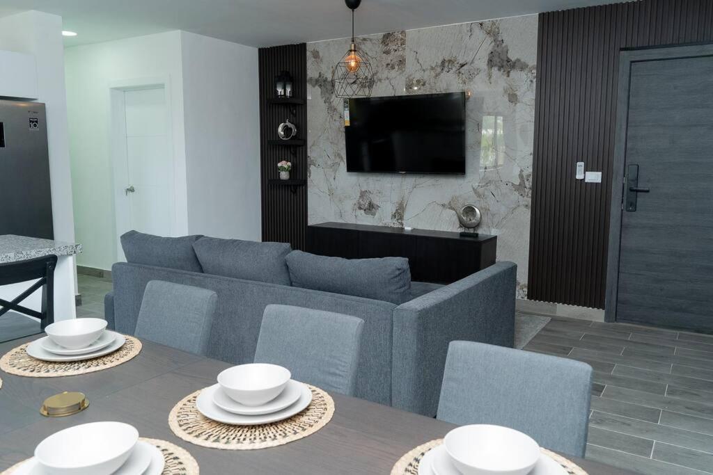 sala de estar con sofá azul y TV en “Hermoso Apartamento En Bávaro” en Punta Cana