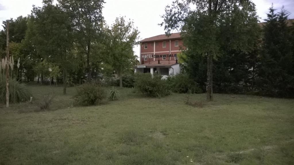 ein Haus inmitten eines Feldes mit Bäumen in der Unterkunft Hotel San Vitale in Medicina