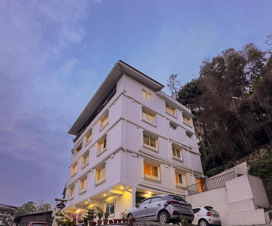 ein weißes Gebäude mit davor geparkt in der Unterkunft Hotel Sherabling in Gangtok