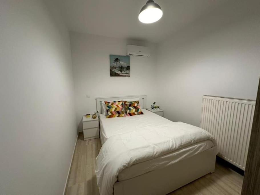 ein weißes Schlafzimmer mit einem Bett und einer weißen Wand in der Unterkunft Quiet simple brand new luxury apartment by the sea in Athen