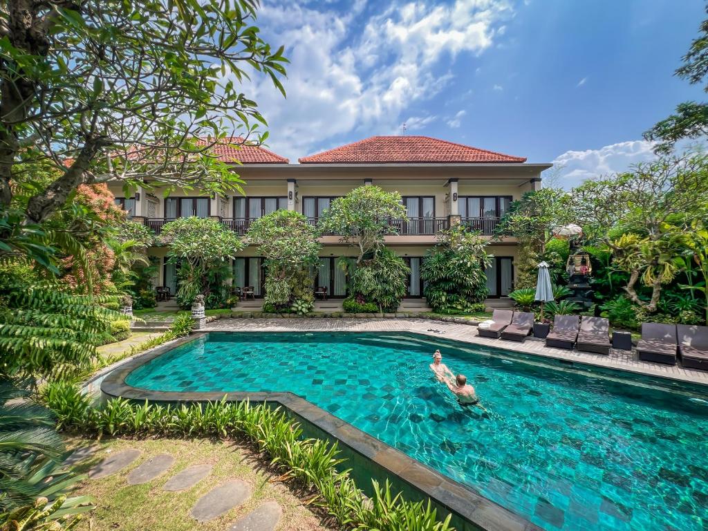 an image of a swimming pool in front of a house at The Mudru Resort by Pramana Villas in Ubud