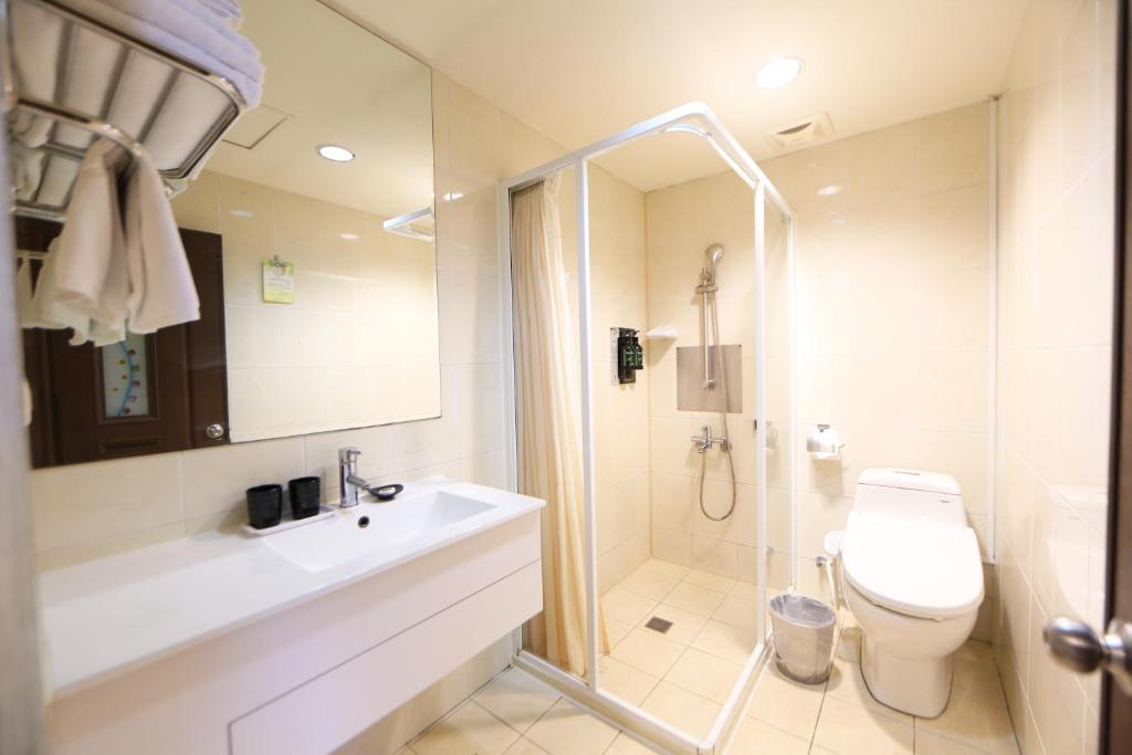 e bagno con servizi igienici, lavandino e doccia. di Grand Earl Hotel a Douliu