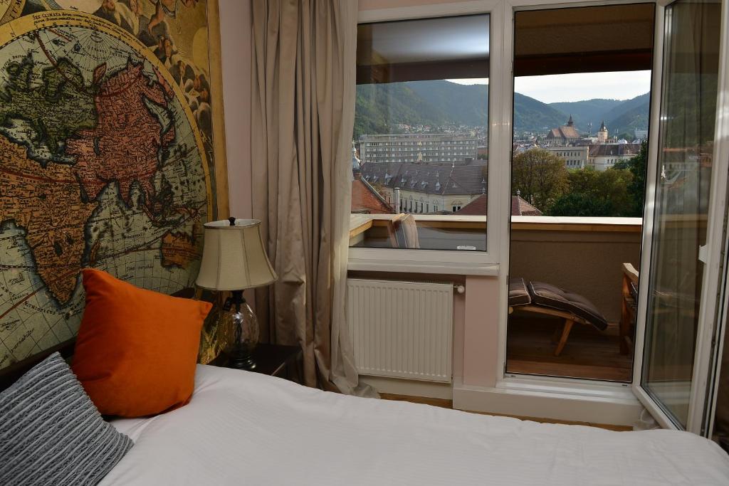 a hotel room with a bed and a large window at Top View Apartaments in Braşov
