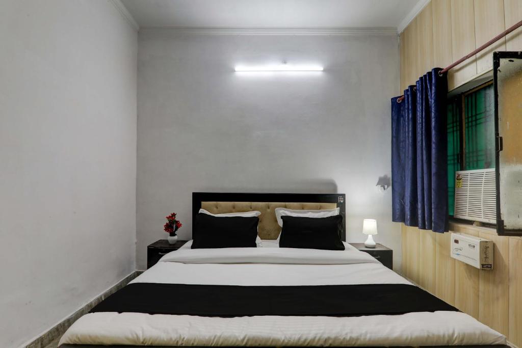a bedroom with a large bed with blue curtains at OYO Flagship Dripp Stay Inn in Lucknow