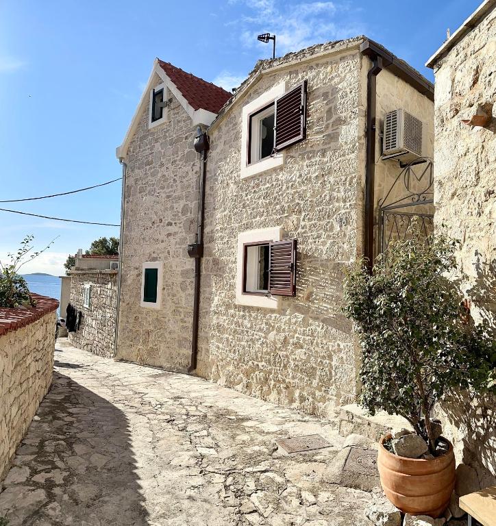 a stone building with a potted plant in front of it at Secret House Andrea in Primošten