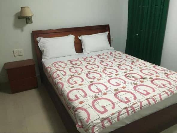 una camera con un letto con una coperta rossa e bianca di Home Hưng Trang a Dien Bien Phu