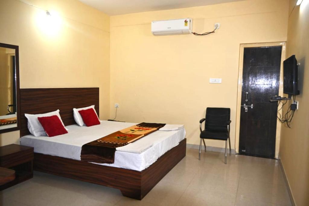 a hotel room with a bed and a chair at Goroomgo Green Akress Bhubaneswar in Bhubaneshwar