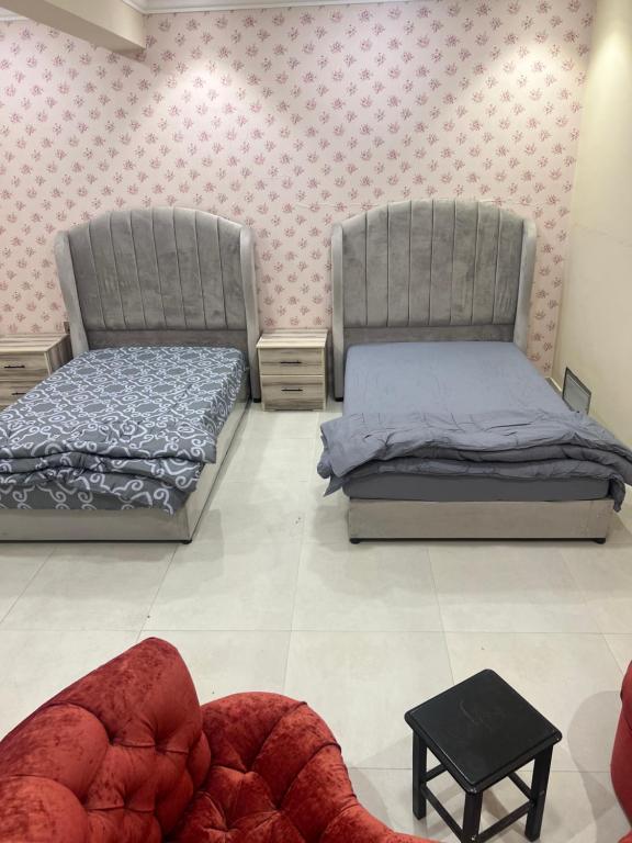 una camera con due letti e un divano di Glory Resort a Al Ahsa