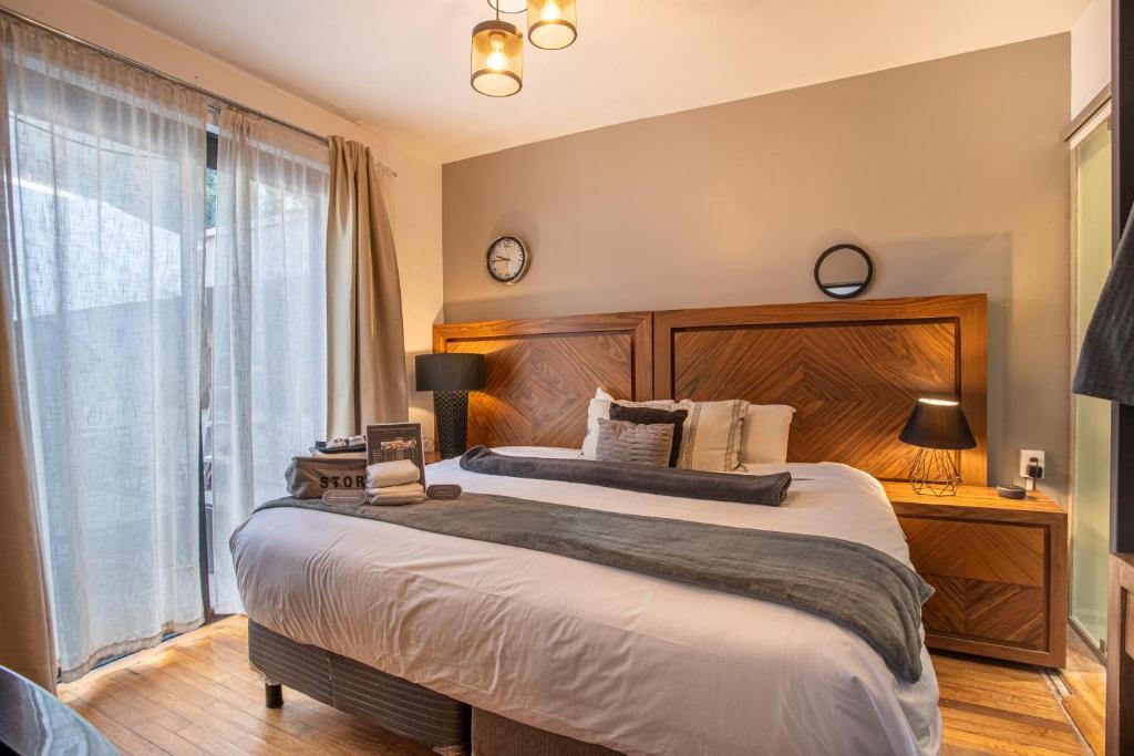 a bedroom with a large bed and a large window at Experience México City Condesa, Central Location, Rooftop Terrace, Coworking, Amazing Artistic Place in Mexico City
