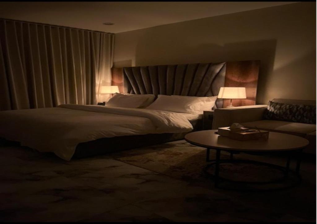 a bedroom with a bed and a couch and a table at أستديو بدخول ذكي حي الربوة in Riyadh