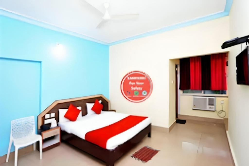 a bedroom with a bed and a microwave and a kitchen at Goroomgo Dittu Holiday inn puri-Near Nilandri Beach-Best Experince Ever in Puri