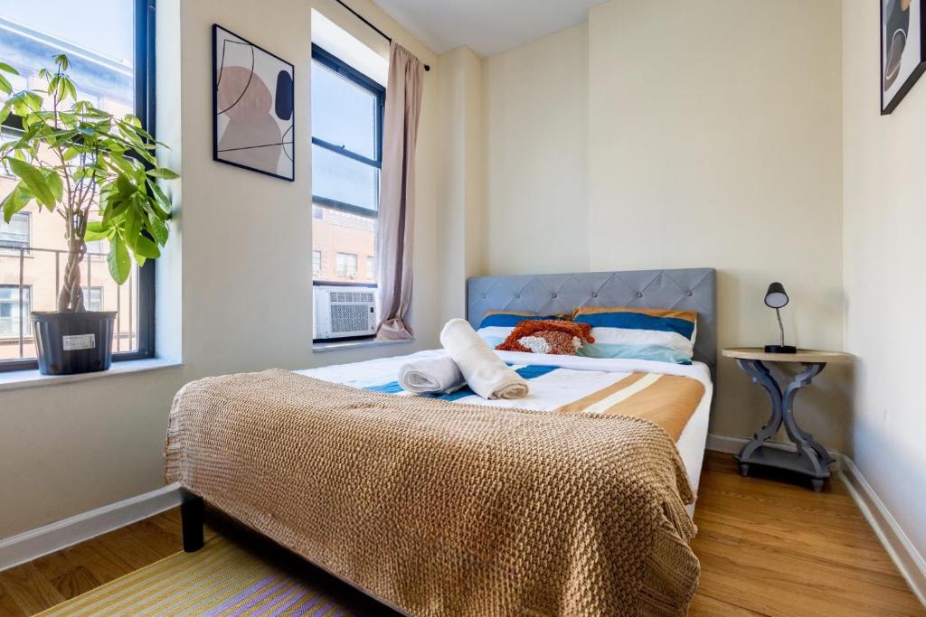 Spacious 4BD Gem in Manhattan في نيويورك: غرفة نوم بسرير ونوافذ