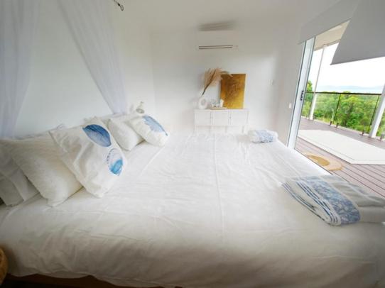 ein großes weißes Bett in einem Zimmer mit Fenster in der Unterkunft DUENDE Sirène Mermaid in Midgeton