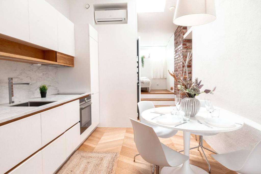 a kitchen and dining room with a white table and chairs at 2ndhomes Ullanlinna Penthouse Apartments in Helsinki