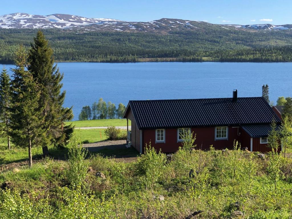 a house with a view of a lake and mountains at Nyrestaurert og koselig hytte ved Skjelbredvatnet. in Sandvika