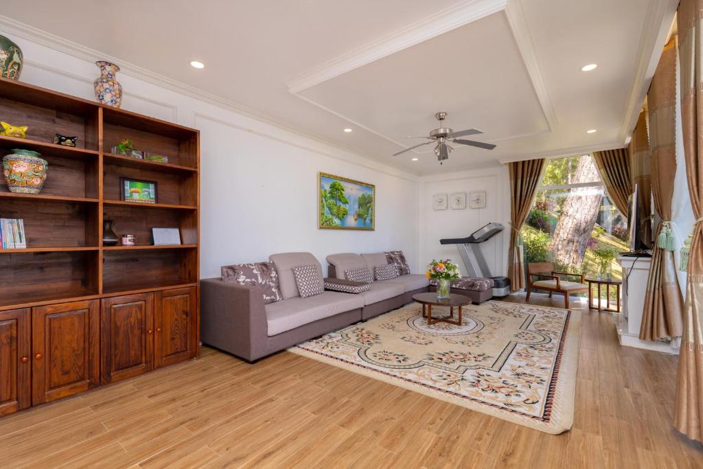 ein Wohnzimmer mit einer Couch und einem Tisch in der Unterkunft Biệt Thự Lan Anh Đà Lạt in Da Lat