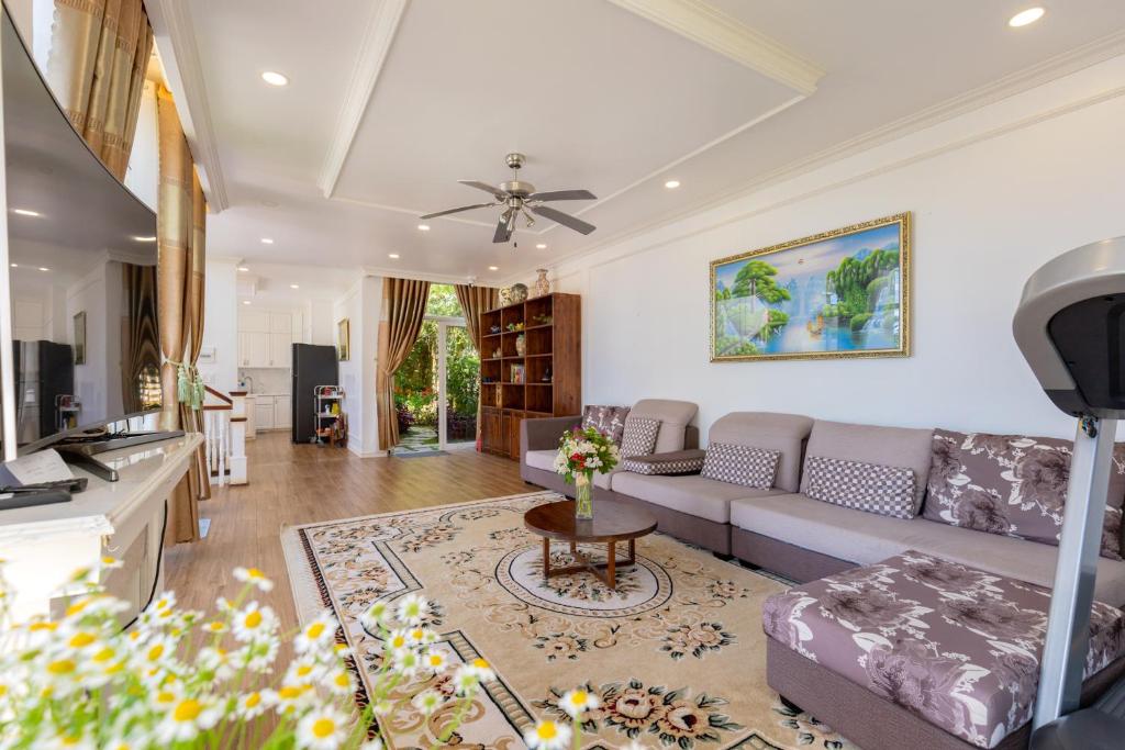 ein Wohnzimmer mit einer Couch und einem Tisch in der Unterkunft Biệt Thự Lan Anh Đà Lạt in Da Lat