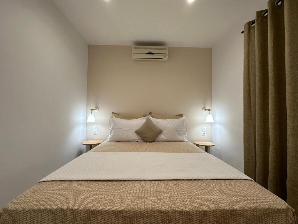 una camera da letto con un grande letto con due comodini di House Garli a Psakoudia