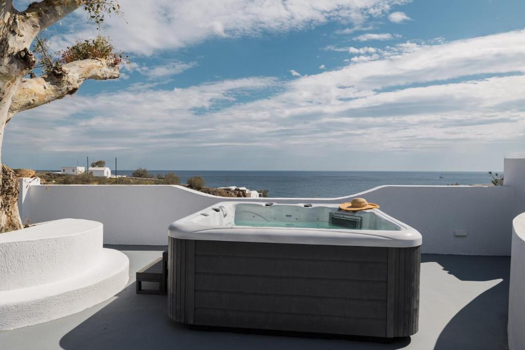 a hot tub on a balcony with the ocean at Red beach Harmony Suites Stone house in Akrotiri