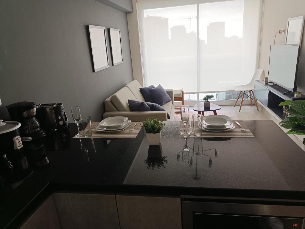 a kitchen with a table with plates and glasses on it at Studio Bohemio in Lima