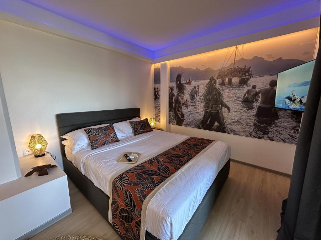 パペーテにあるOnonui Airport Studioのベッドルーム1室(壁に絵画が描かれたベッド1台付)