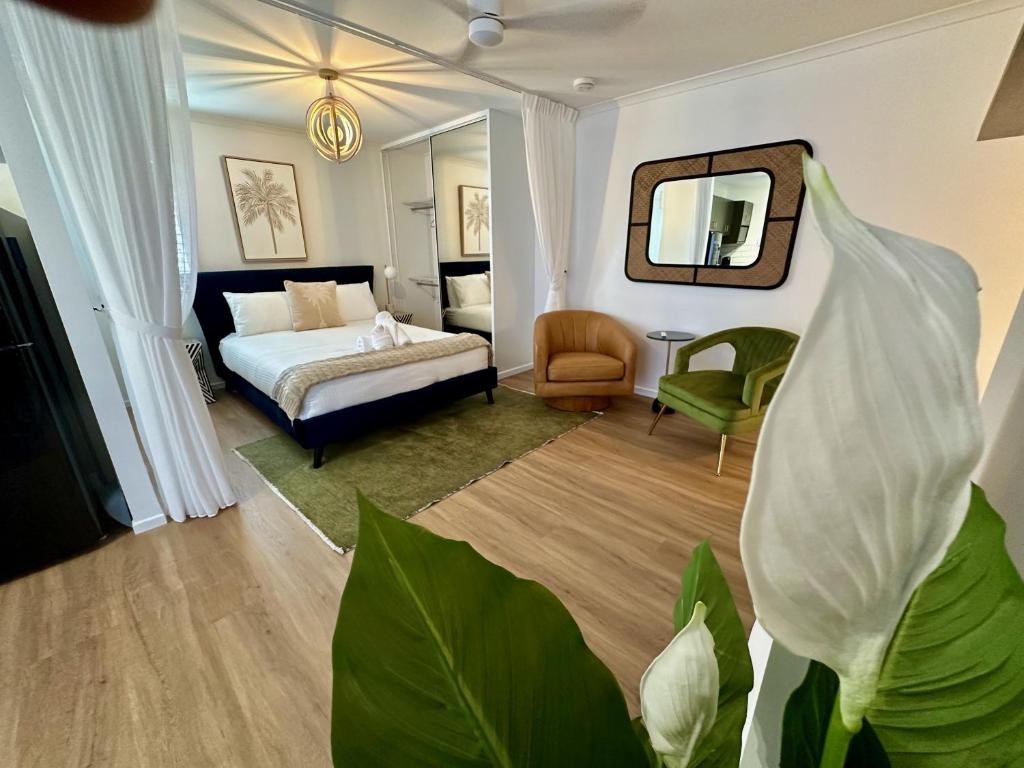 Schlafzimmer mit einem Bett und einem Spiegel in der Unterkunft Luxe Palm Studio Villa - In the heart of Edge Hill in Edge Hill