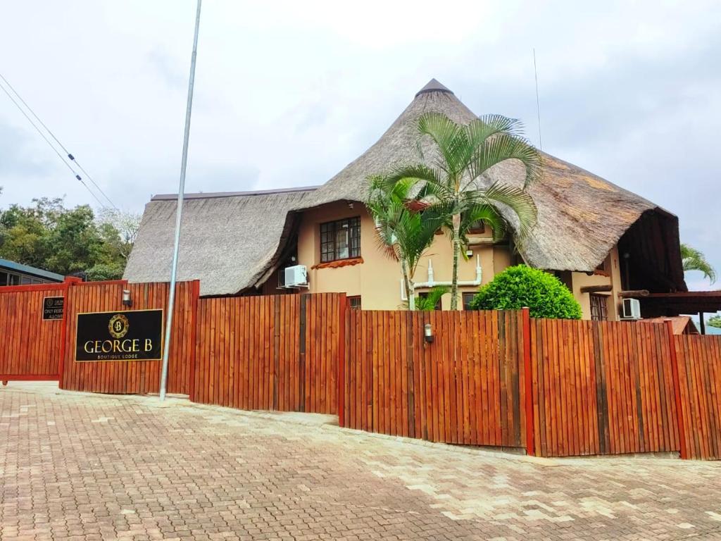 a house with a fence in front of it at GEORGE B BOUTIQUE LODGE in Tzaneen