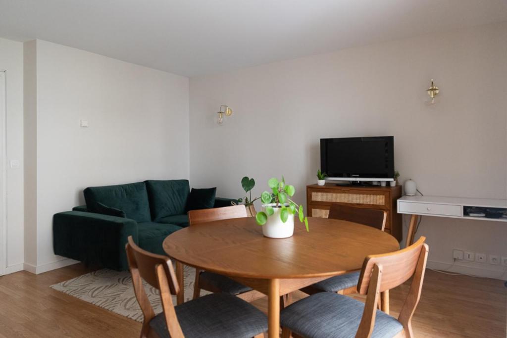 - un salon avec une table et un canapé vert dans l'établissement Pretty cocoon of love close to the City of Light, à Montrouge