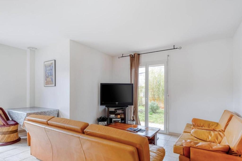 uma sala de estar com um sofá e uma televisão em Splendid family home in Toulouse em Toulouse