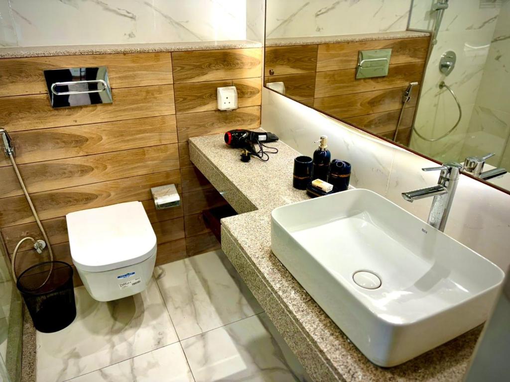 une salle de bain avec un lavabo et des toilettes dans l'établissement Close, à Islamabad