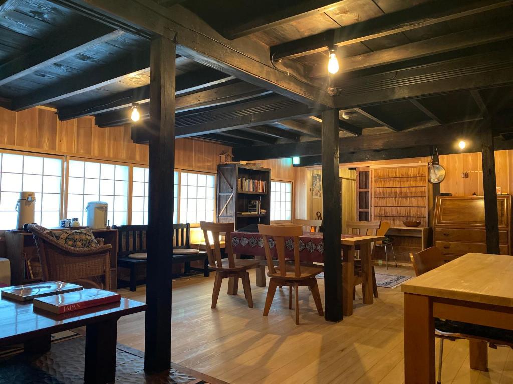 Cette grande chambre dispose de tables et de chaises en bois. dans l'établissement Koyasan Space, à Koyasan