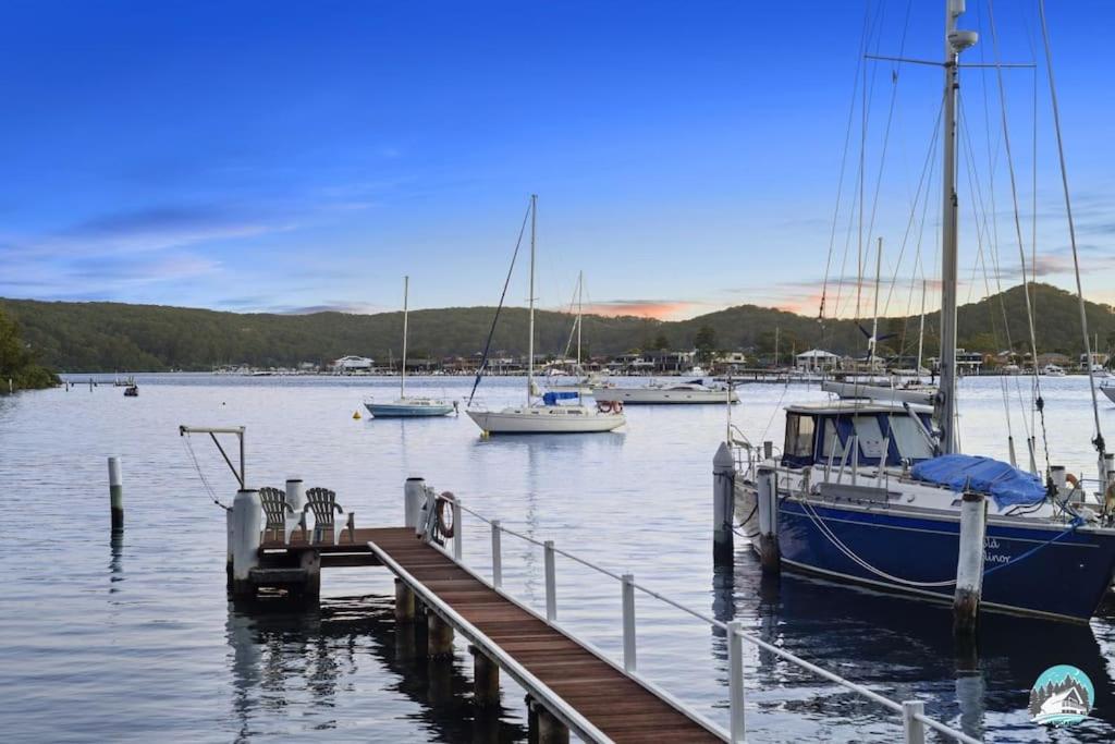 a boat is docked at a dock with other boats at Aircabin - Daleys Point - Waterfront Retreat House in Daleys Point