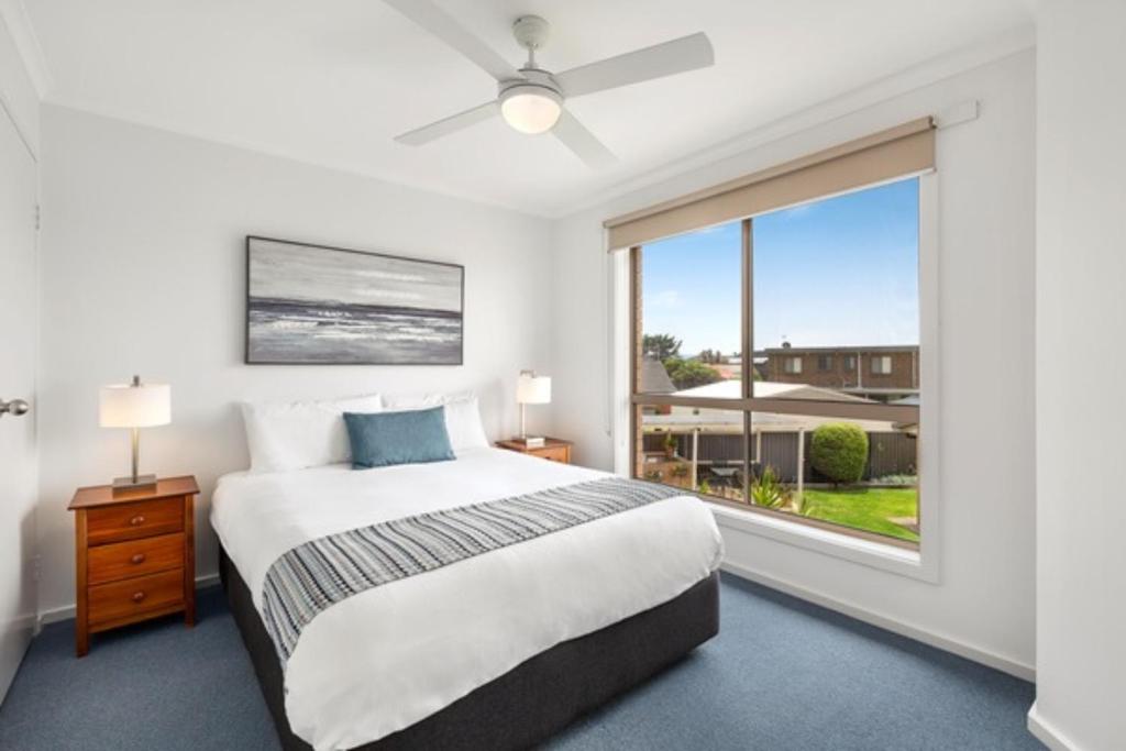 a bedroom with a bed and a large window at Marine Cove Resort in Goolwa South