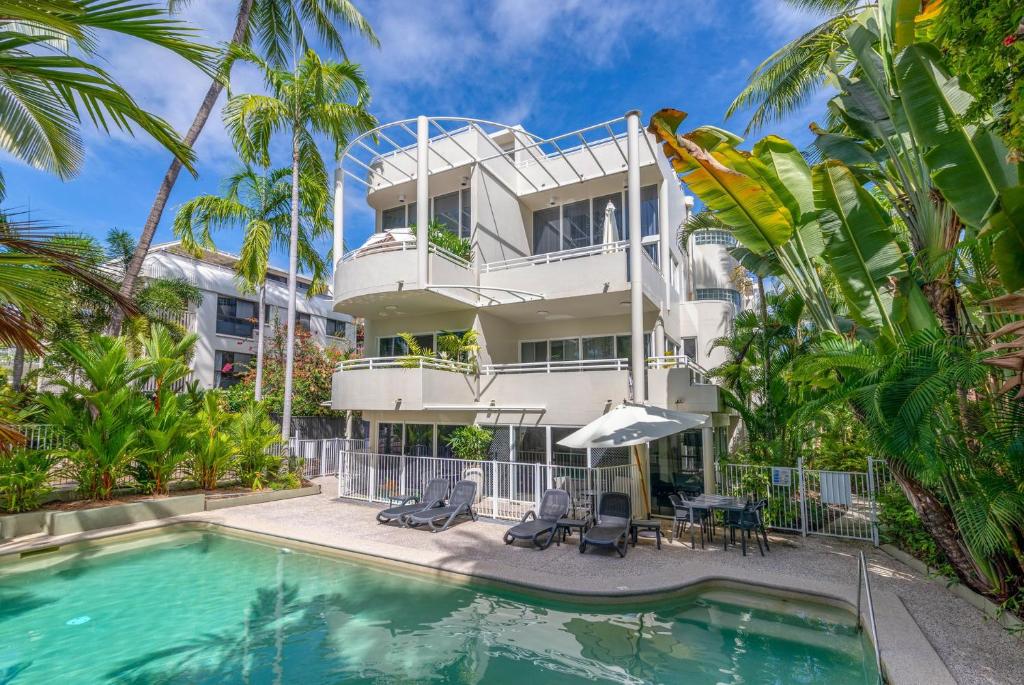 un immeuble d'appartements avec piscine et palmiers dans l'établissement Tropical Escape, à Port Douglas