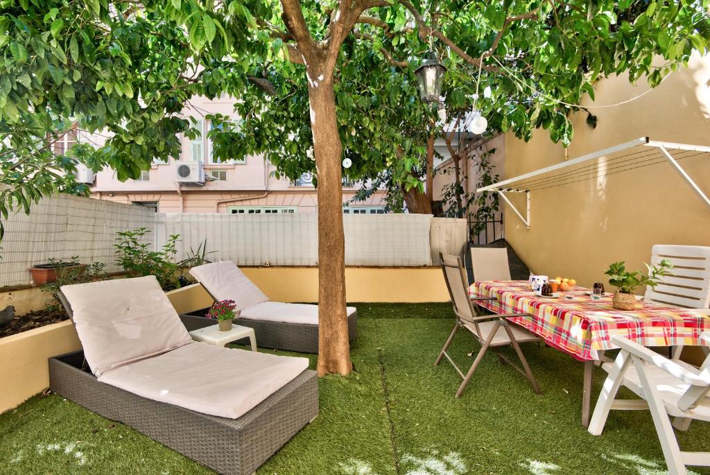 a patio with a table and chairs and a tree at la palais osiris Nice centre jardin wifi clim parking in Nice