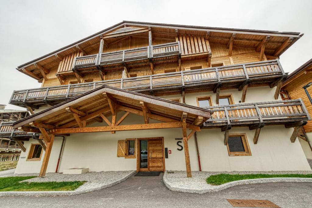 a large wooden building with wooden balconies on it at Eskape Megève - K3 and Eskape Megève - S2- Happy Rentals in Megève