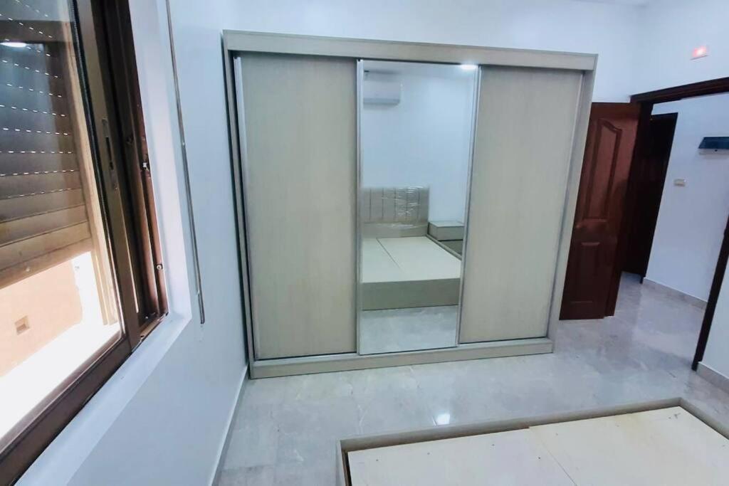 a large glass window in a room with a window at شقة فندقية فاخرة - غرفتا نوم - تلاع العلي in Umm Uthainah