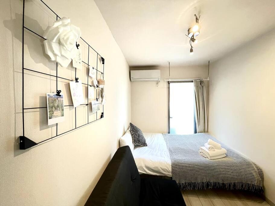 a small bedroom with a bed and a window at Glanz Okubo 101 in Tokyo