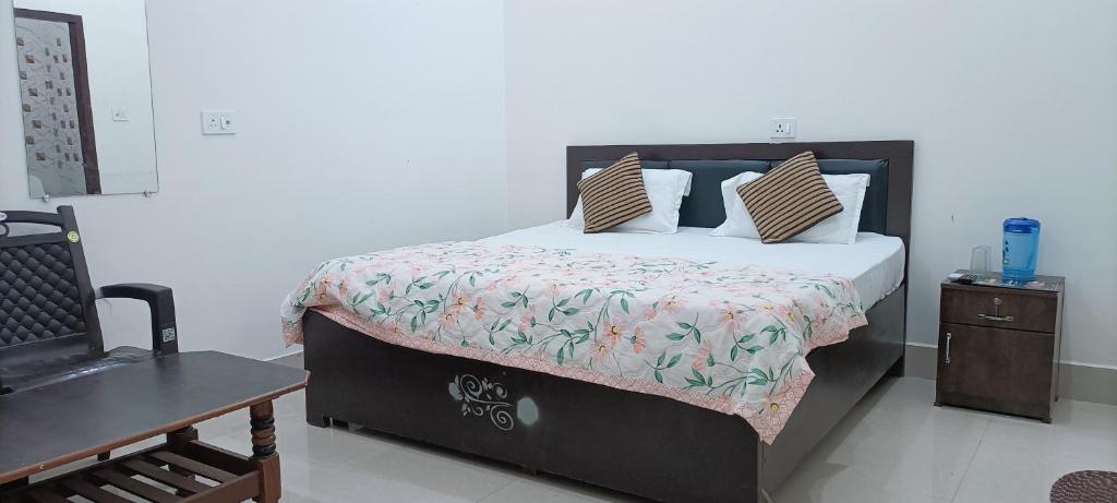 Murli Manohar Palace في فريندافان: غرفة نوم بسرير وطاولة خشبية