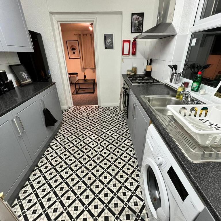 a kitchen with a black and white tiled floor at Old Martl in Colindale