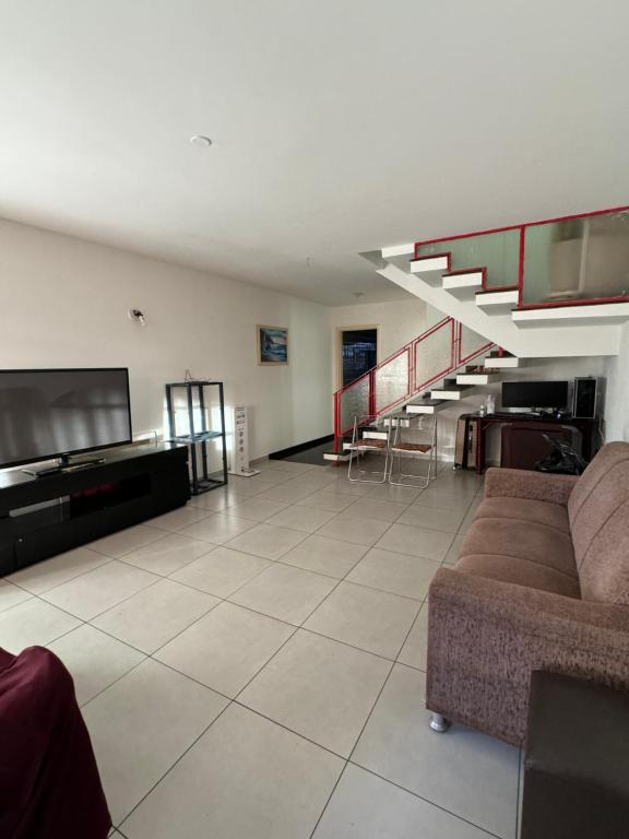 een woonkamer met een bank en een televisie bij Quarto privativo com ótima localização in Sao Paulo